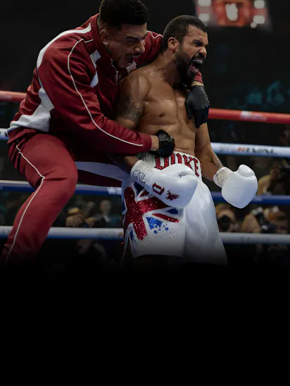 Howard Charles as Duke Kilroy celebrating a boxing match victory with his trainer.